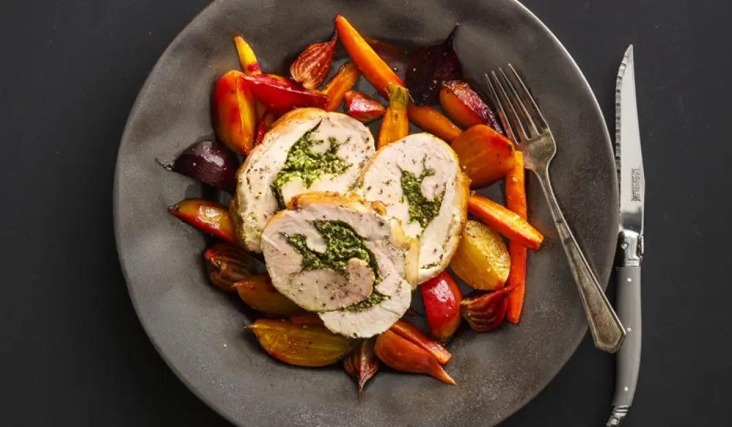 Longe de porc farcie au pesto servie avec légumes rôtis