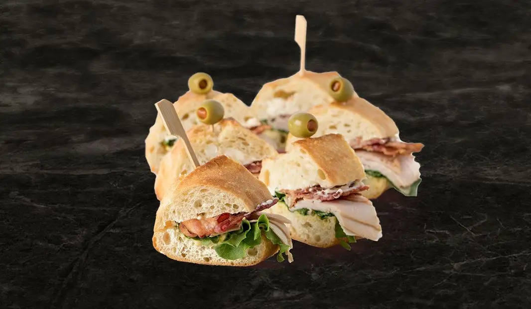 Sandwich au dindon fumé, bacon, laitue et olive verte.