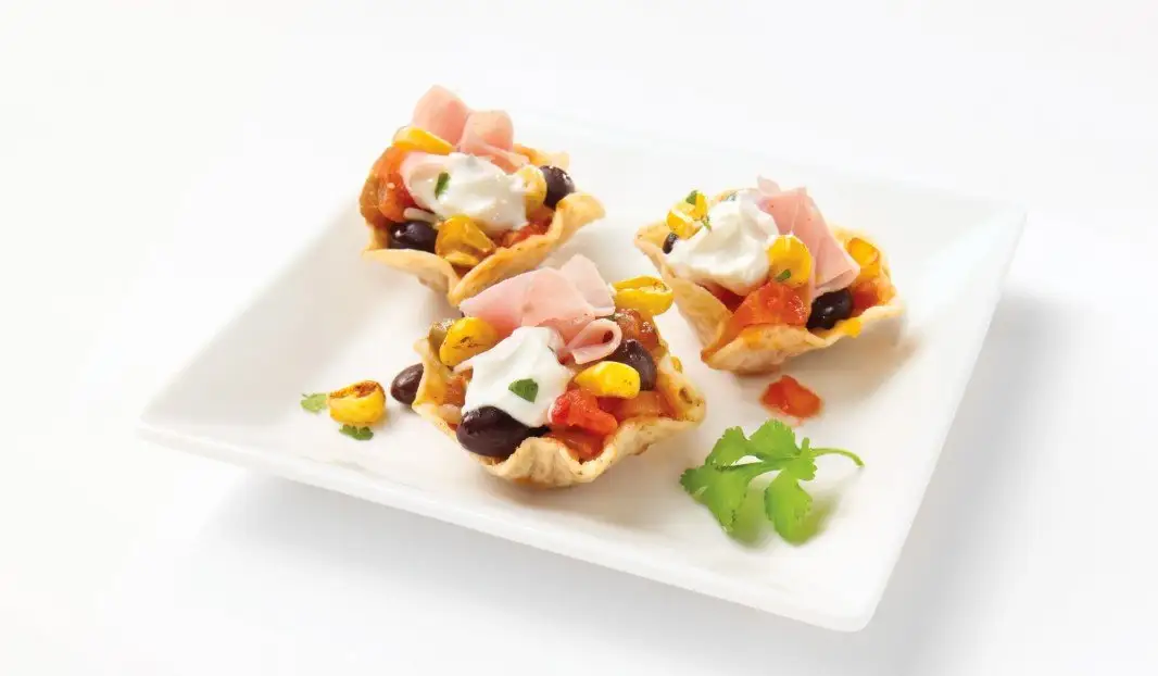 Croustilles garnies de jambon fumé, haricots noirs et fromage fondu