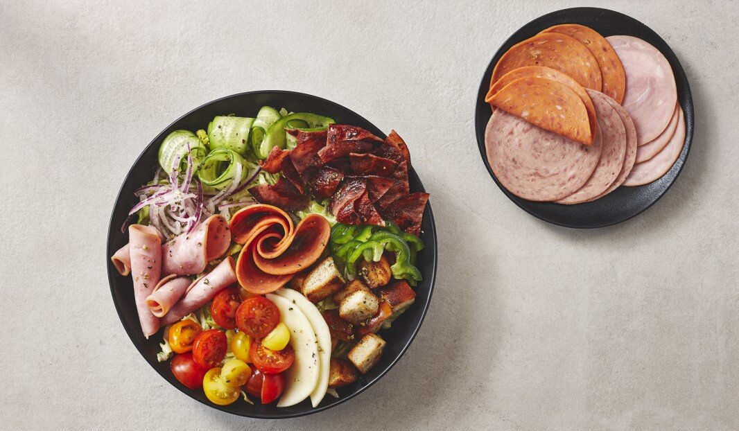 Assiette de charcuterie avec légumes, fromage et croûtons.