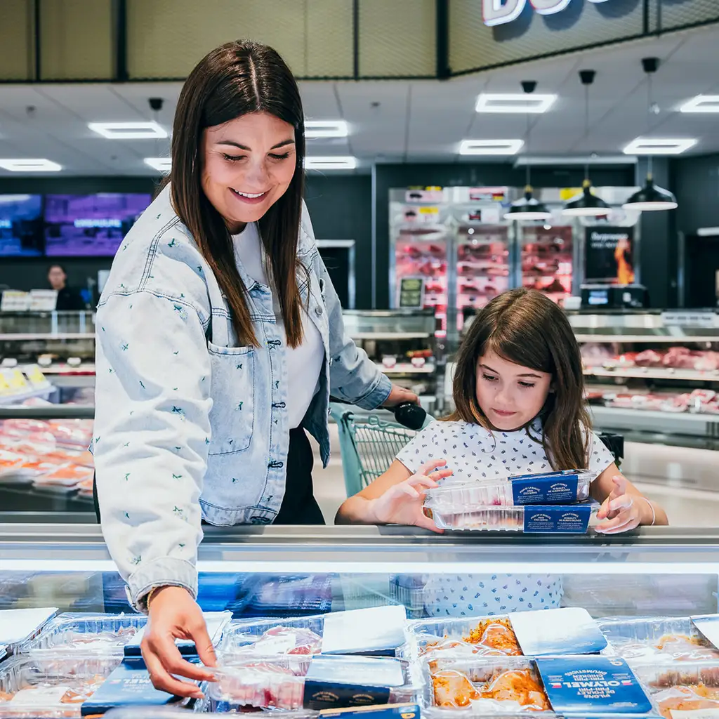 Une maman et sa fille à l'épicerie avec produits Olymel