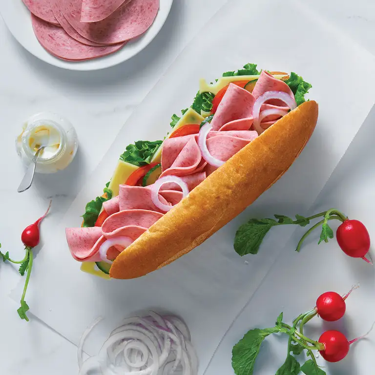 Sandwich au salami tranché avec laitue, tomate, concombre, fromage