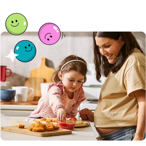Maman et enfant mangeant une pizza et des croquettes de poulet