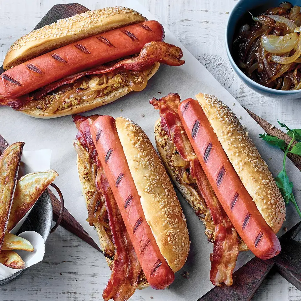 Hot dog au boeuf avec oignons caramélisé et bacon