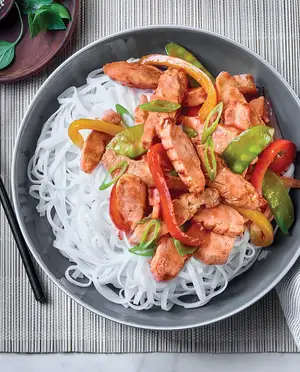 Lanières de poitrine de poulet entièrement cuites et assaisonnées avec isolat de soya servit avec des nouilles de riz et mélange de légumes cuits