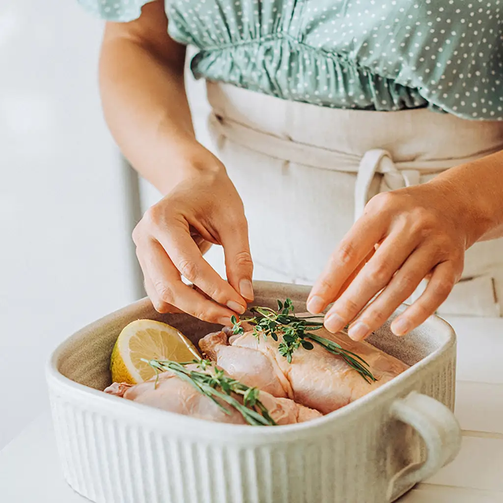 Une personne qui cuisine du poulet