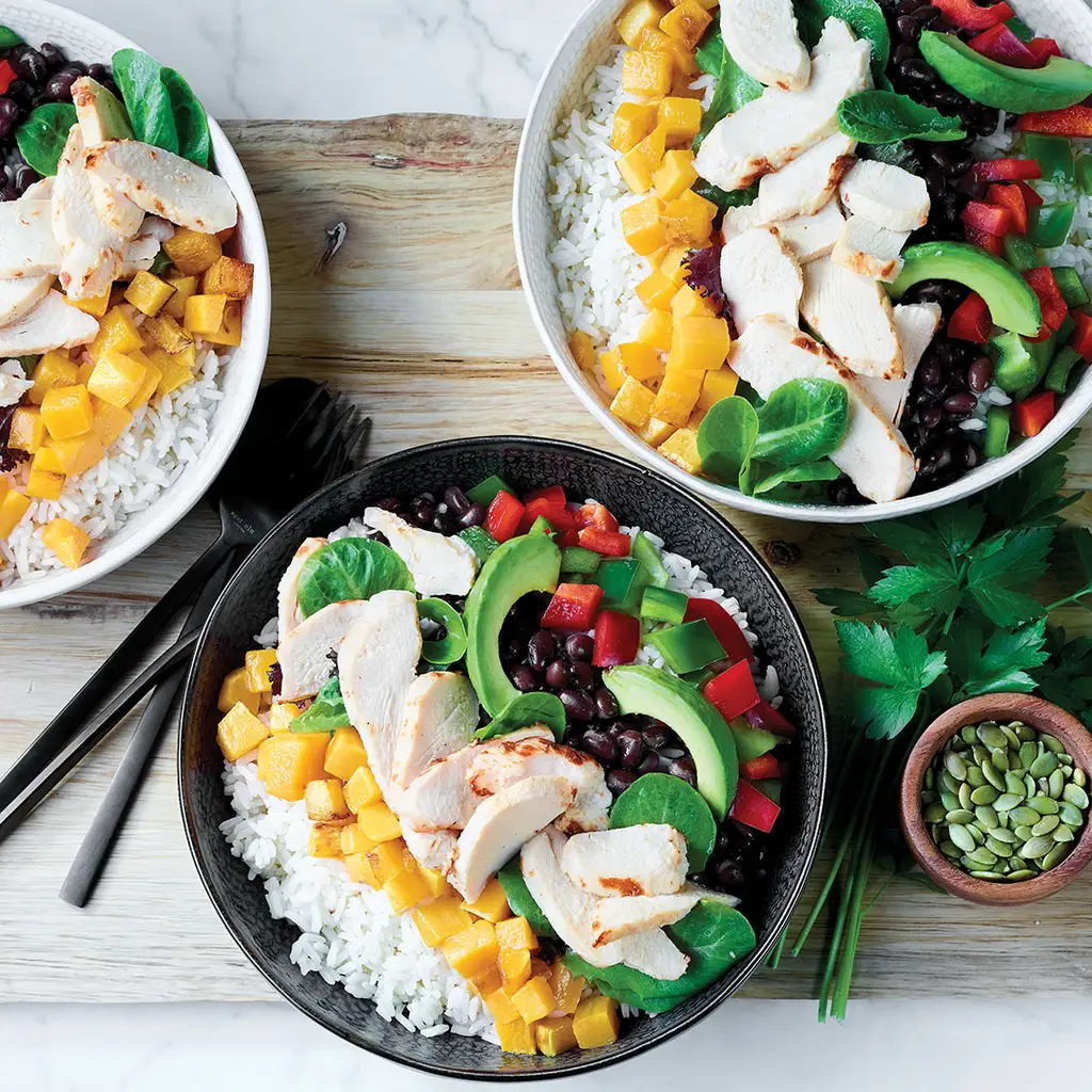 Bol poke de riz avec poulet, mangue, épinards, avocat, fèves rouges, poivrons rouges et poivrons verts