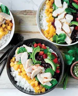 Bol poke de riz avec poulet, mangue, épinards, avocat, fèves rouges, poivrons rouges et poivrons verts
