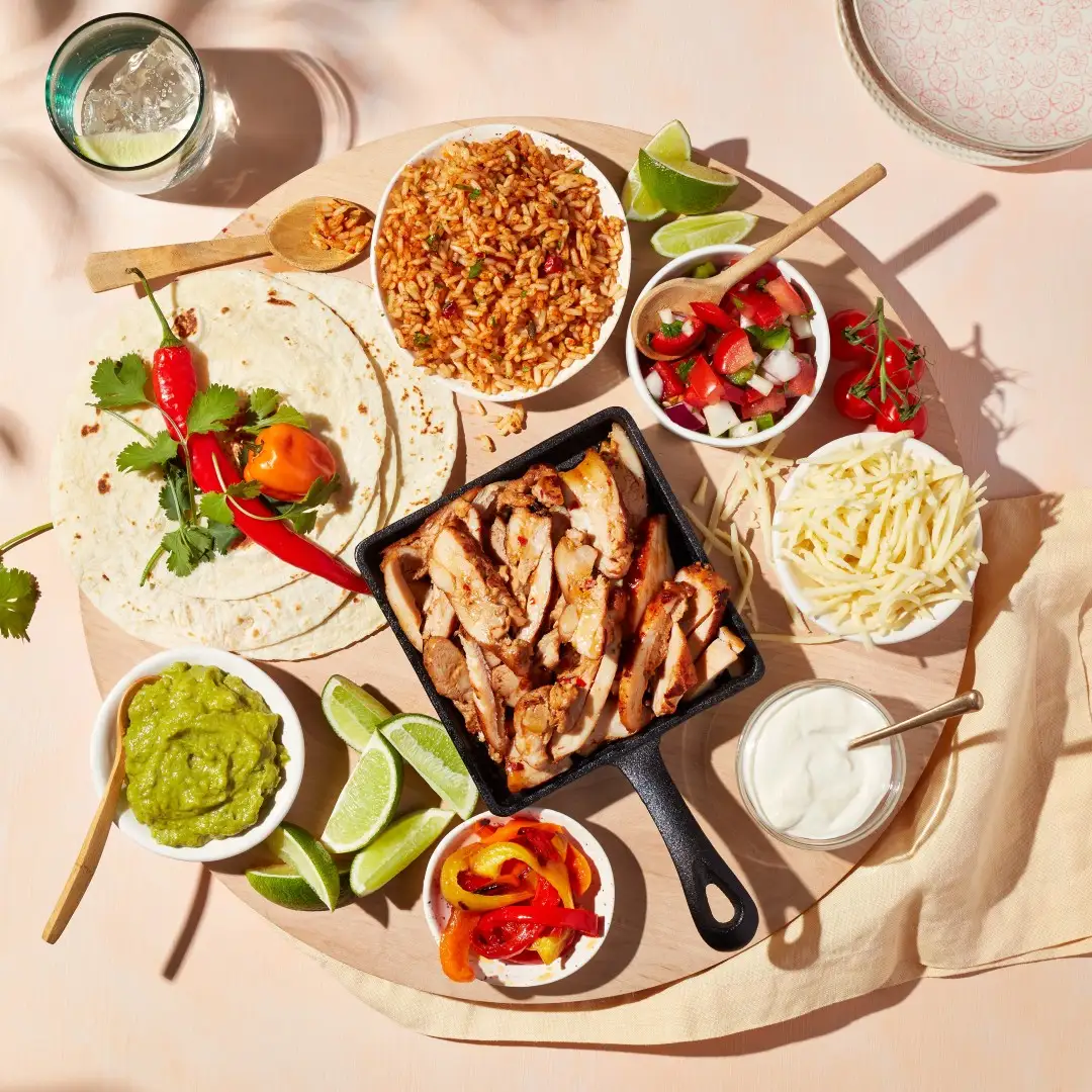 Planche de fajitas aux hauts de cuisse de poulet chili doux et lime, guacamole, poivrons, crème sure, fromage, riz et tortillas
