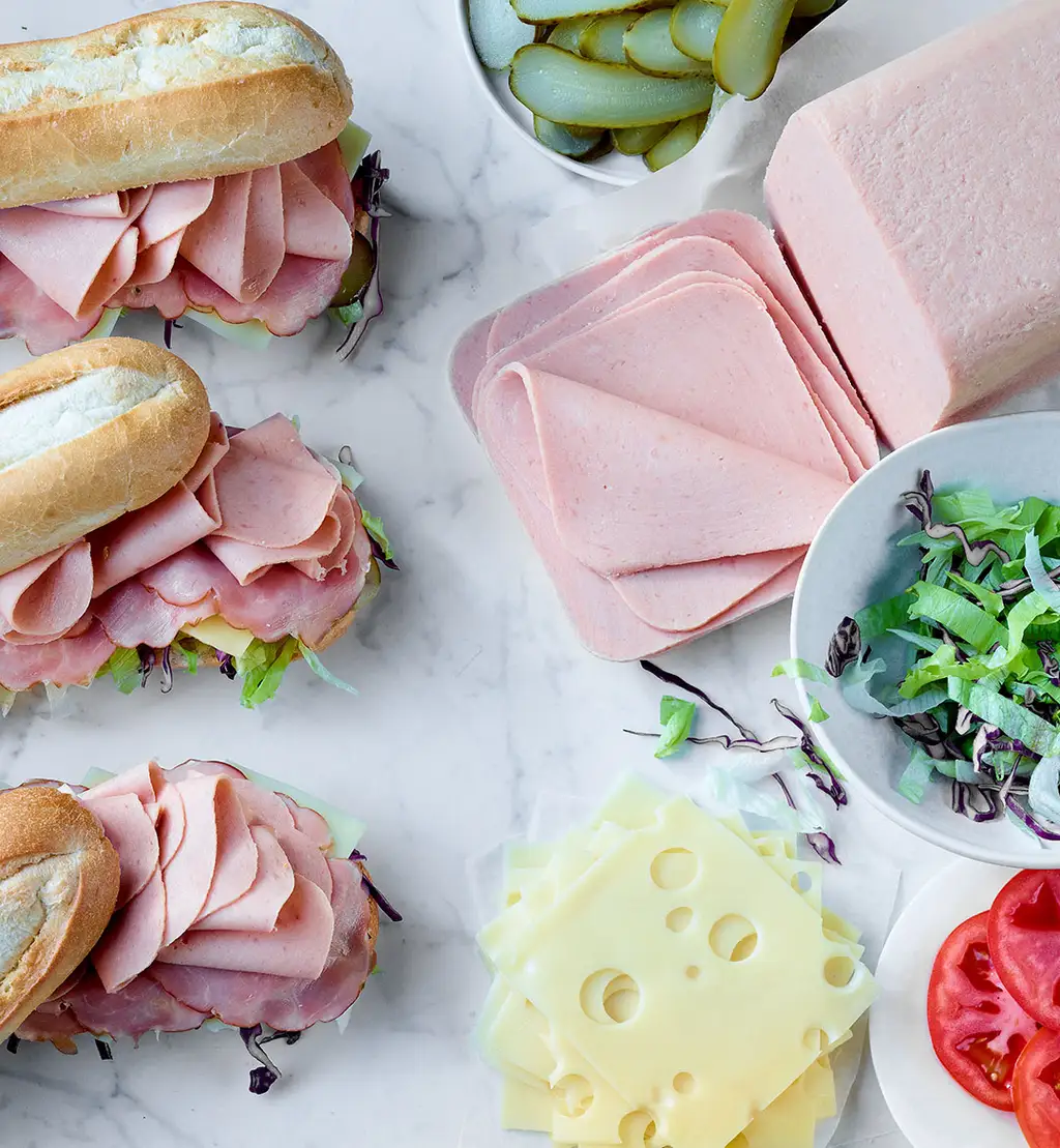 Sous-marins au pain de viande simili-poulet avec cornichons, fromage suisse, laitue et tomate