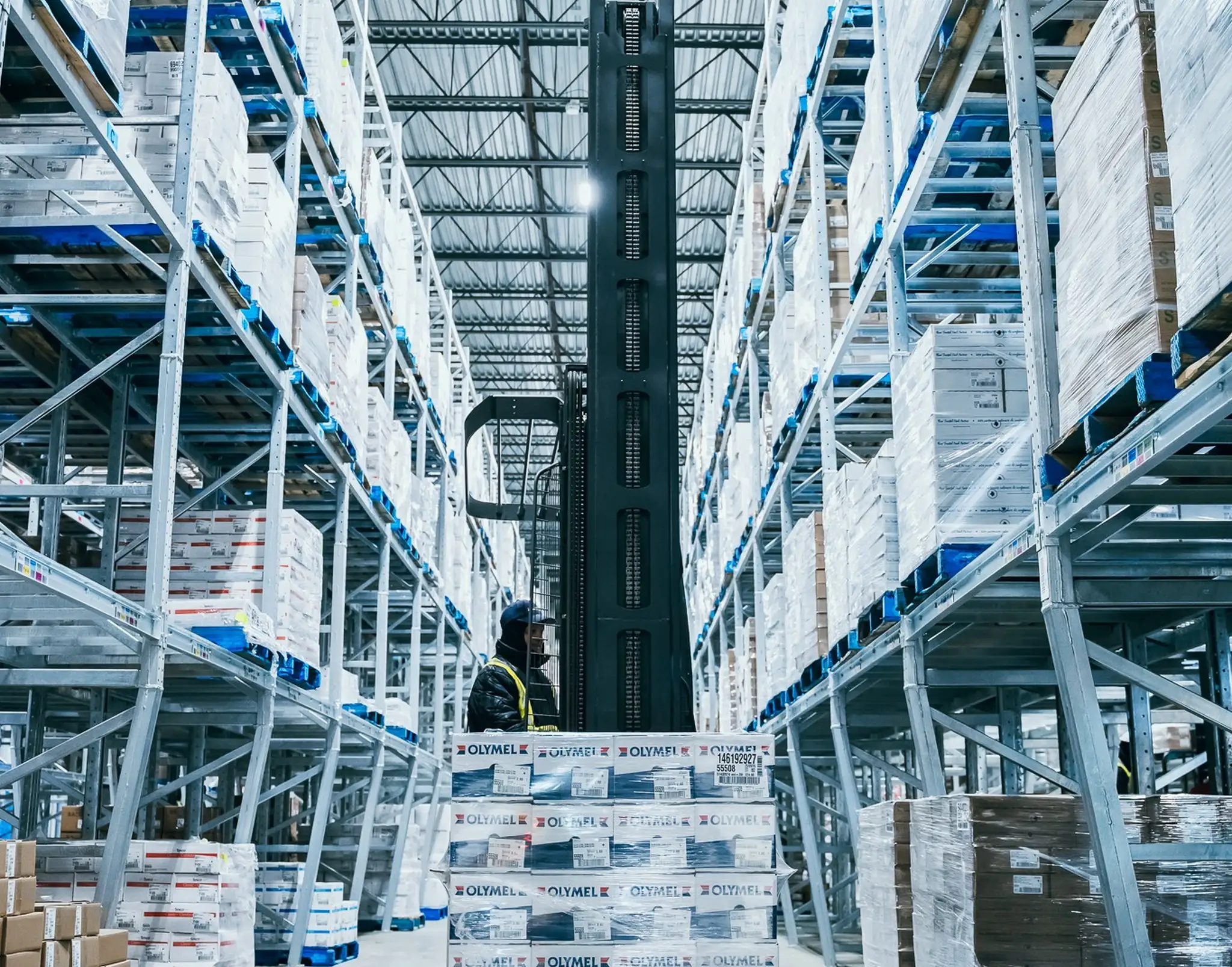 Une personne déplace des palettes dans un centre de distribution d'Olymel