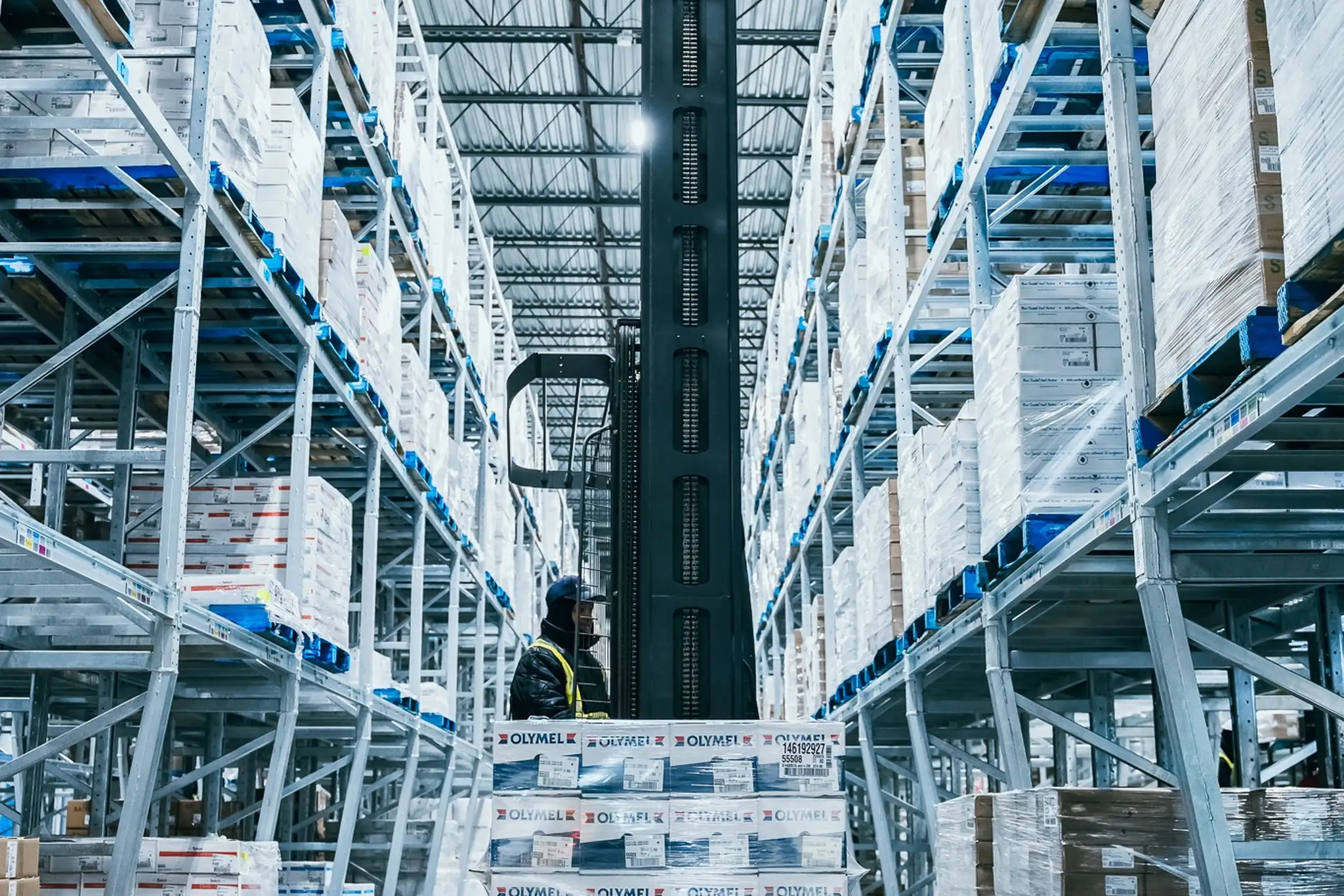 Une personne déplace des palettes dans un centre de distribution d'Olymel
