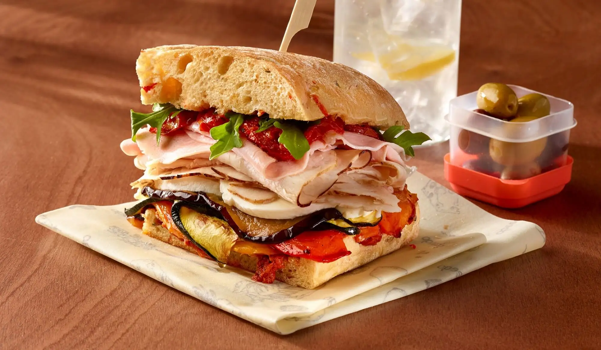 Sandwich ciabatta garni de dinde, jambon et légumes rôtis