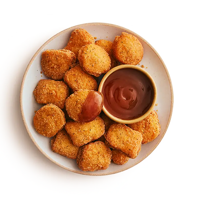 Assiette de pépites de poulet sans gluten avec sauce aux prunes.