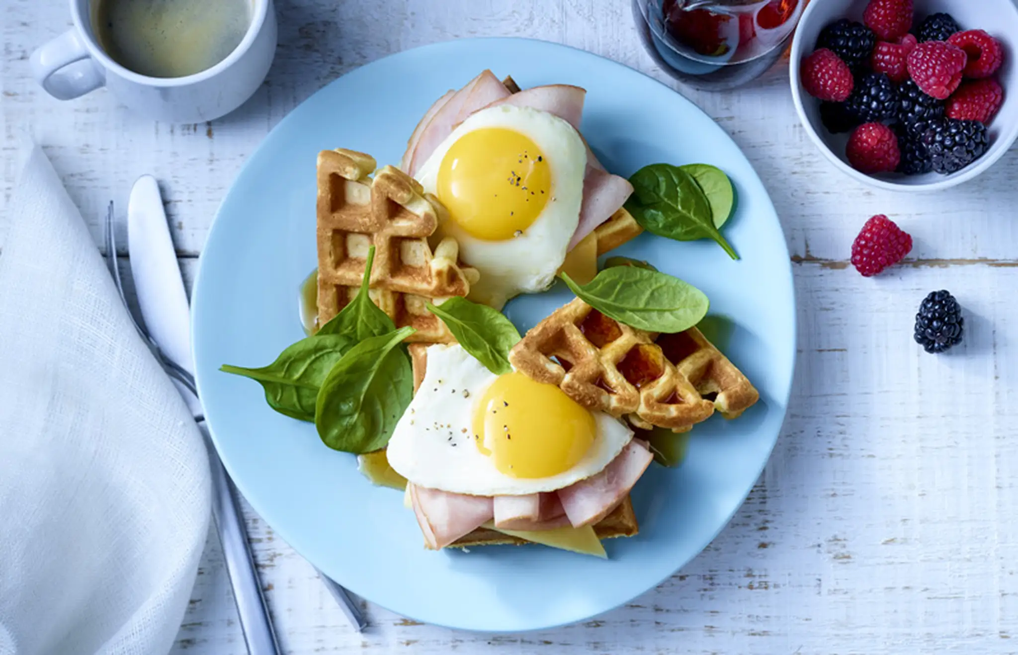 Assiette déjeuner avec gaufres, jambon, œufs et café