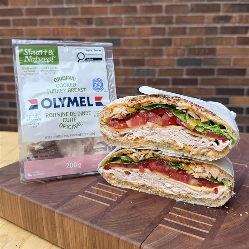Sandwich à la dinde sur planche de bois et emballage de poitrine de dinde cuite original Olymel Smart & Natural