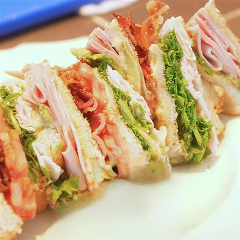 Club sandwich au jambon fumé forêt noire sur assiette blanche