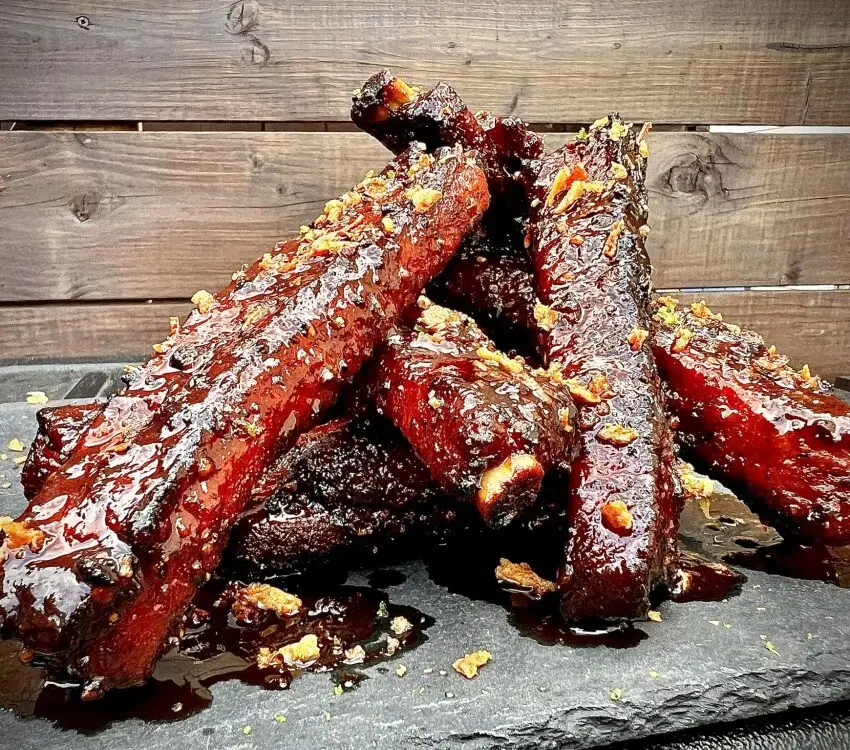 Côtes de levées glacées avec sauce épaisse et morceaux d'oignons frits.