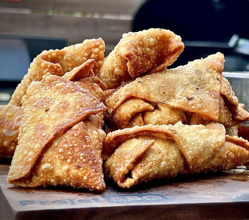 Beignets frits dorés et croustillants sur une surface en bois.
